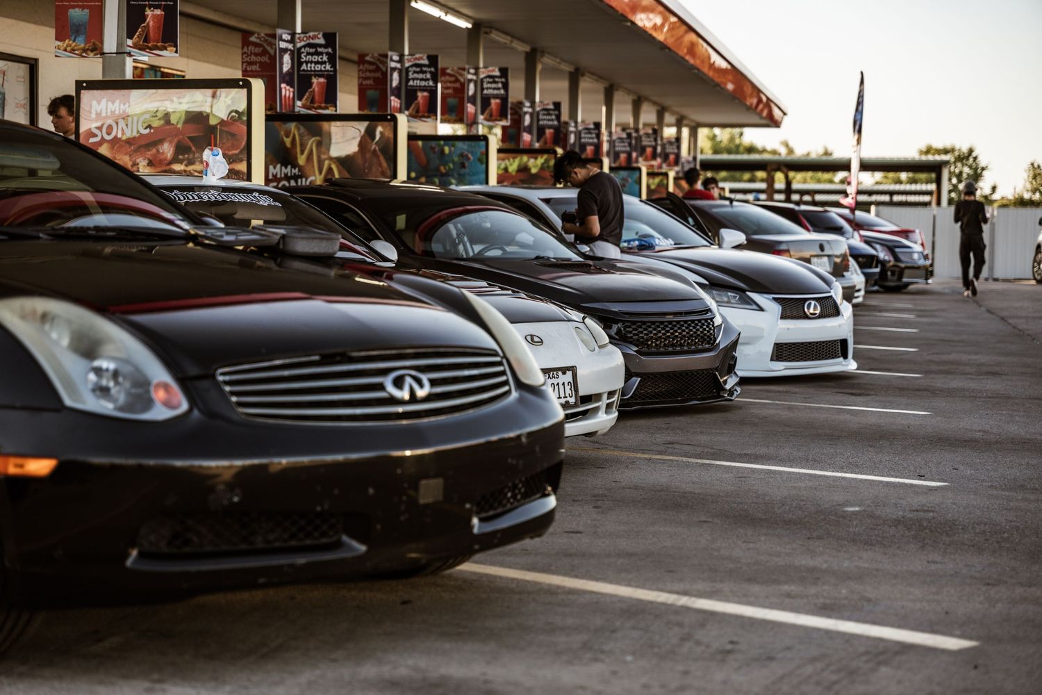 Row of black Infiniti G35 coupes showcased at car meet.