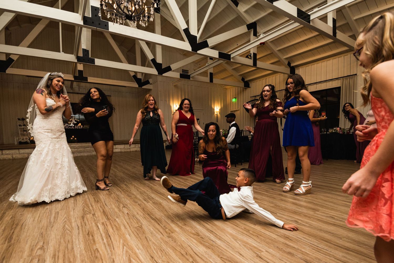 Wedding party having fun on the dance floor as someone strikes a dramatic pose.