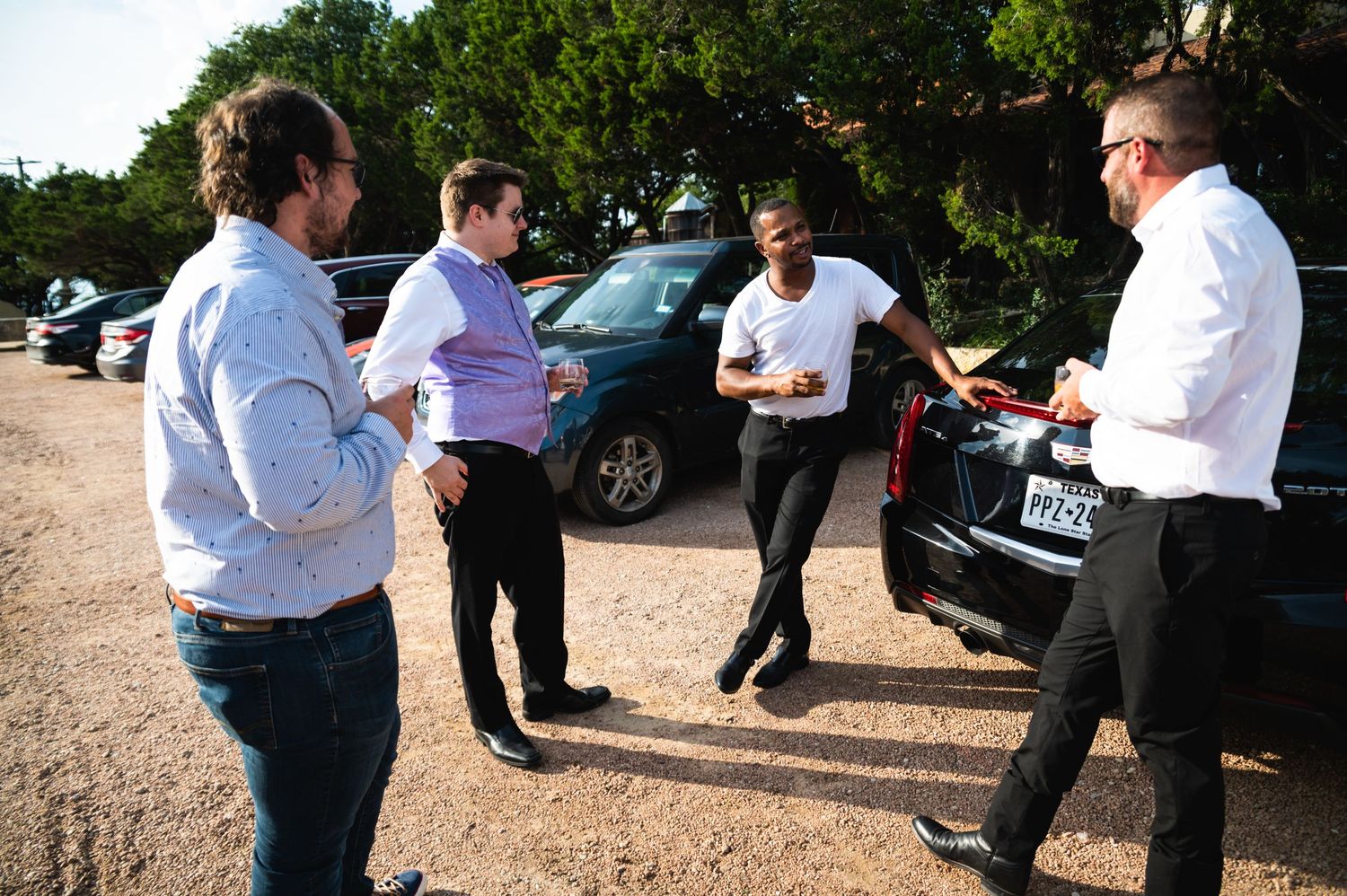 Group of people having conversation in outdoor parking area.