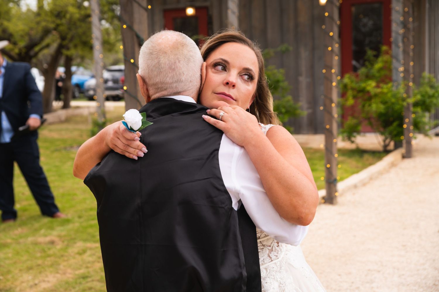 An emotional moment captured during a wedding ceremony on a rustic pathway.