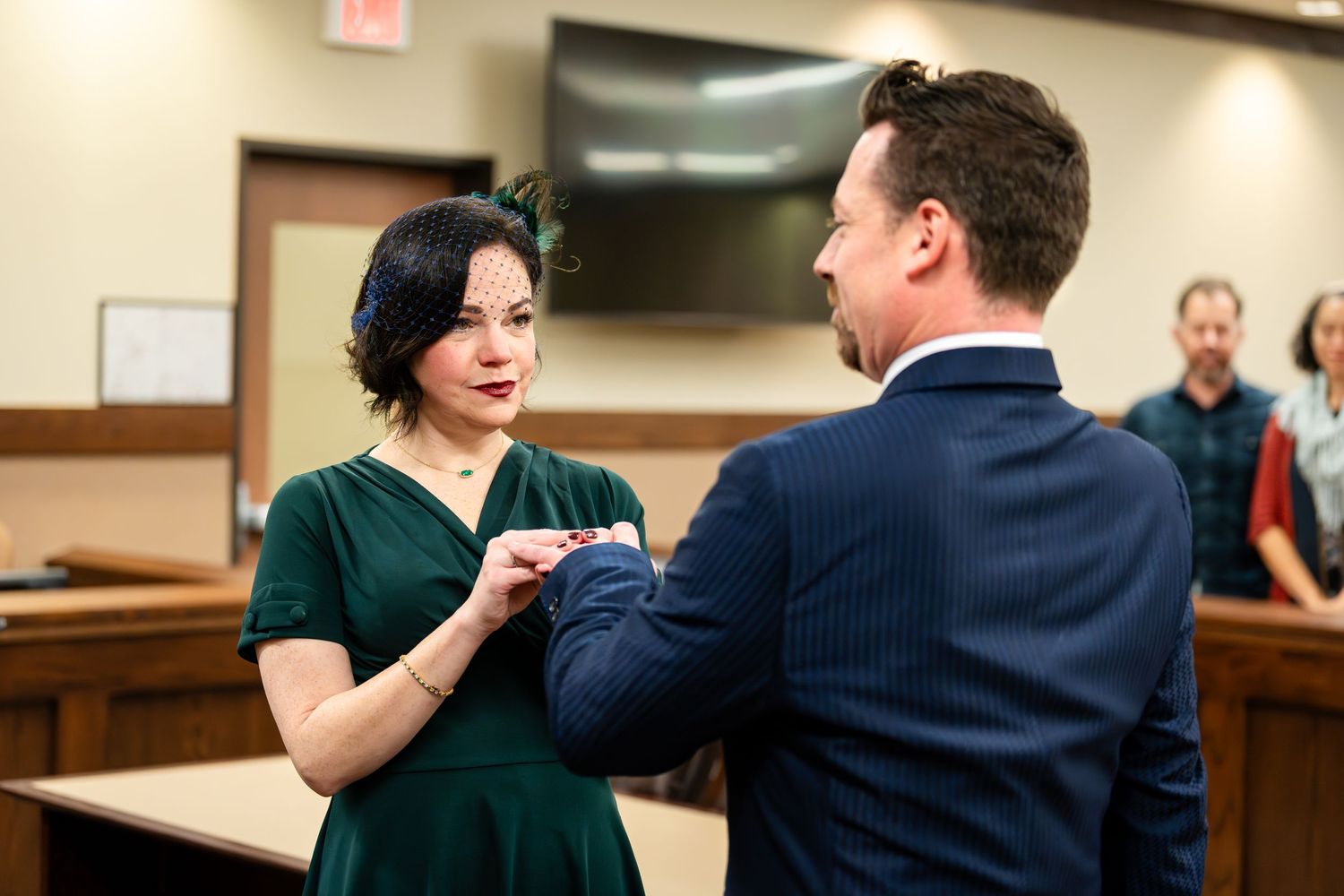 A couple exchanges rings during their intimate courthouse wedding ceremony.