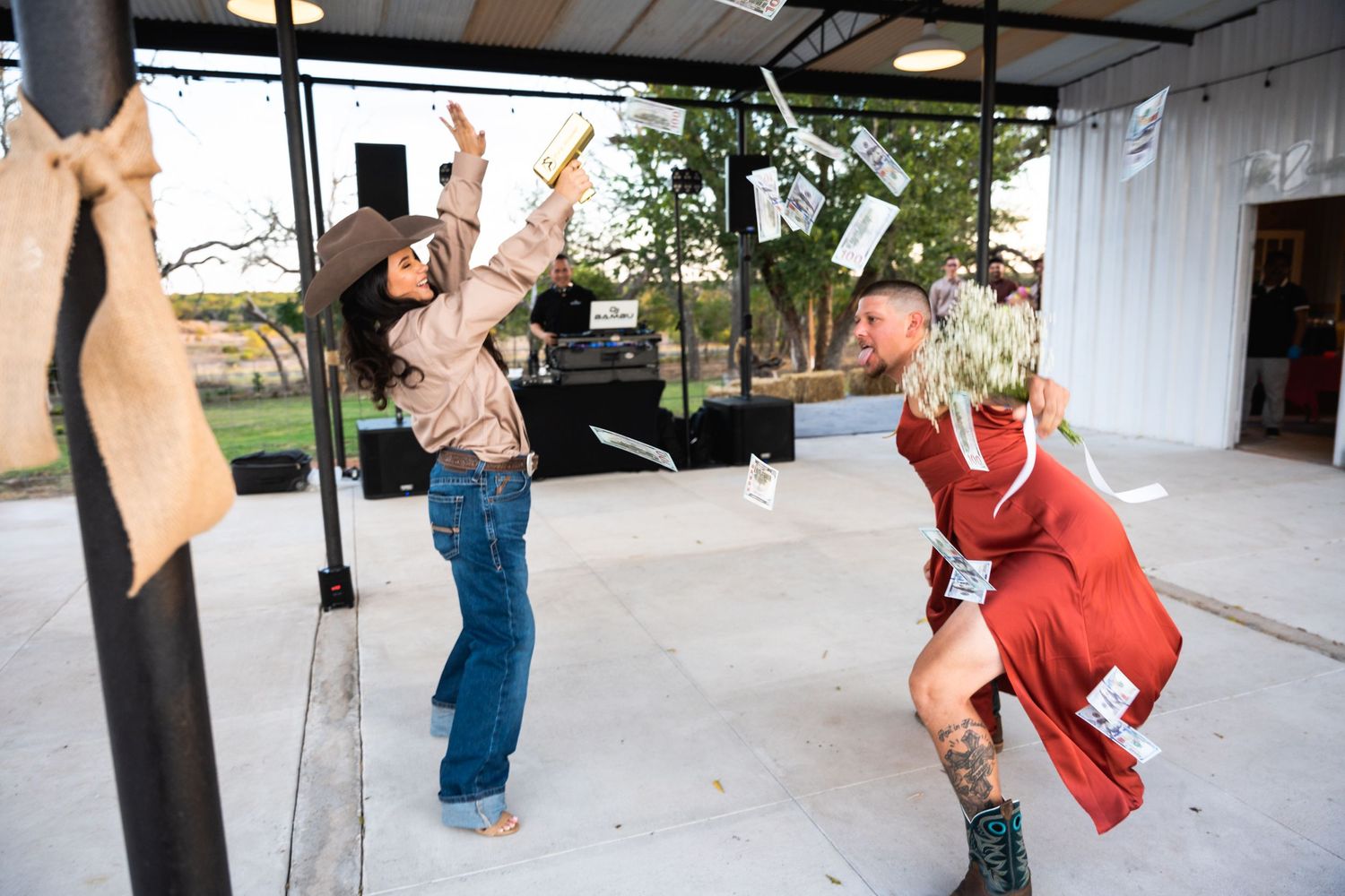 Energetic dancers perform during wedding reception at covered outdoor venue.