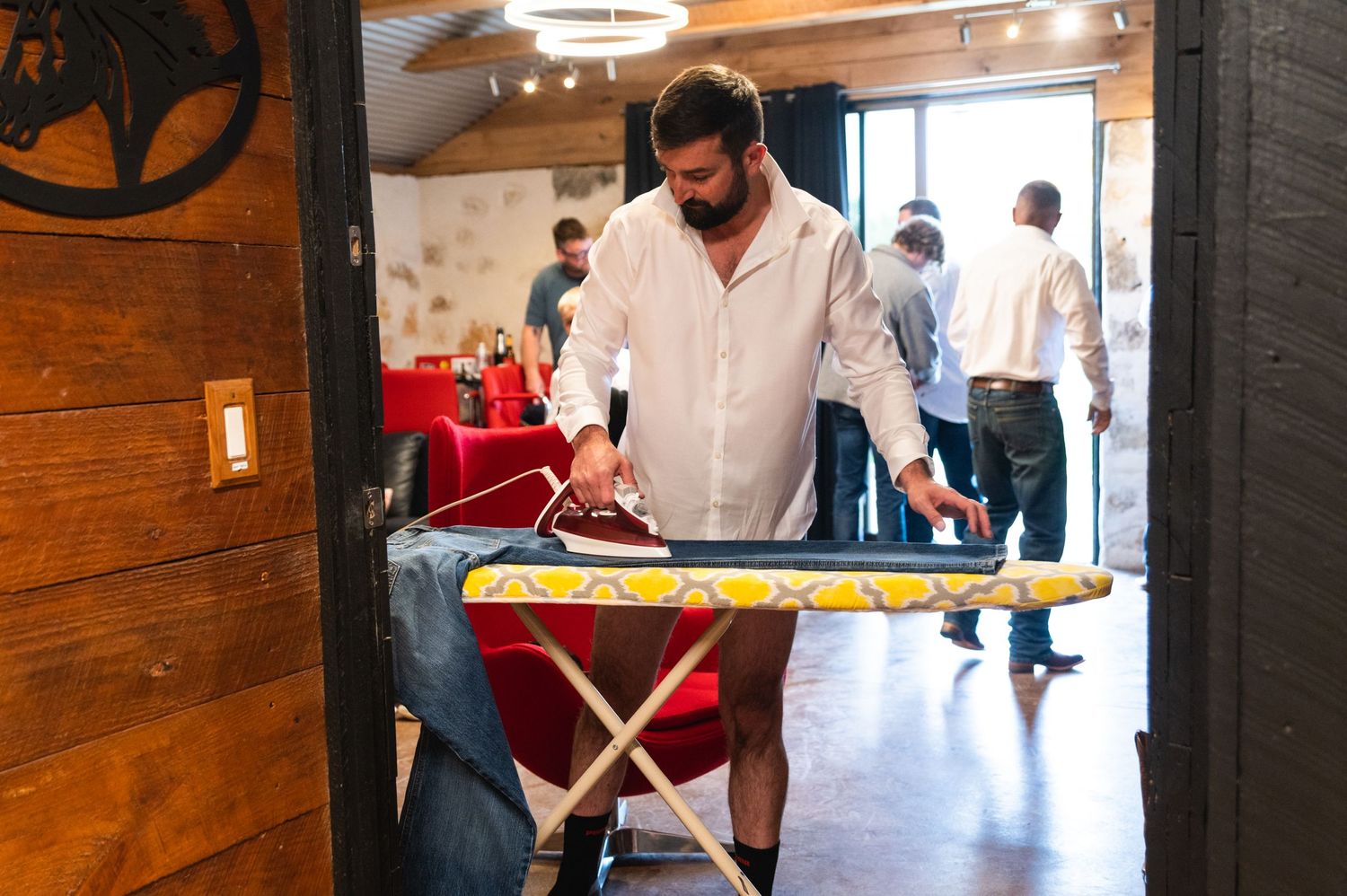Person in white shirt ironing clothes on an ironing board.