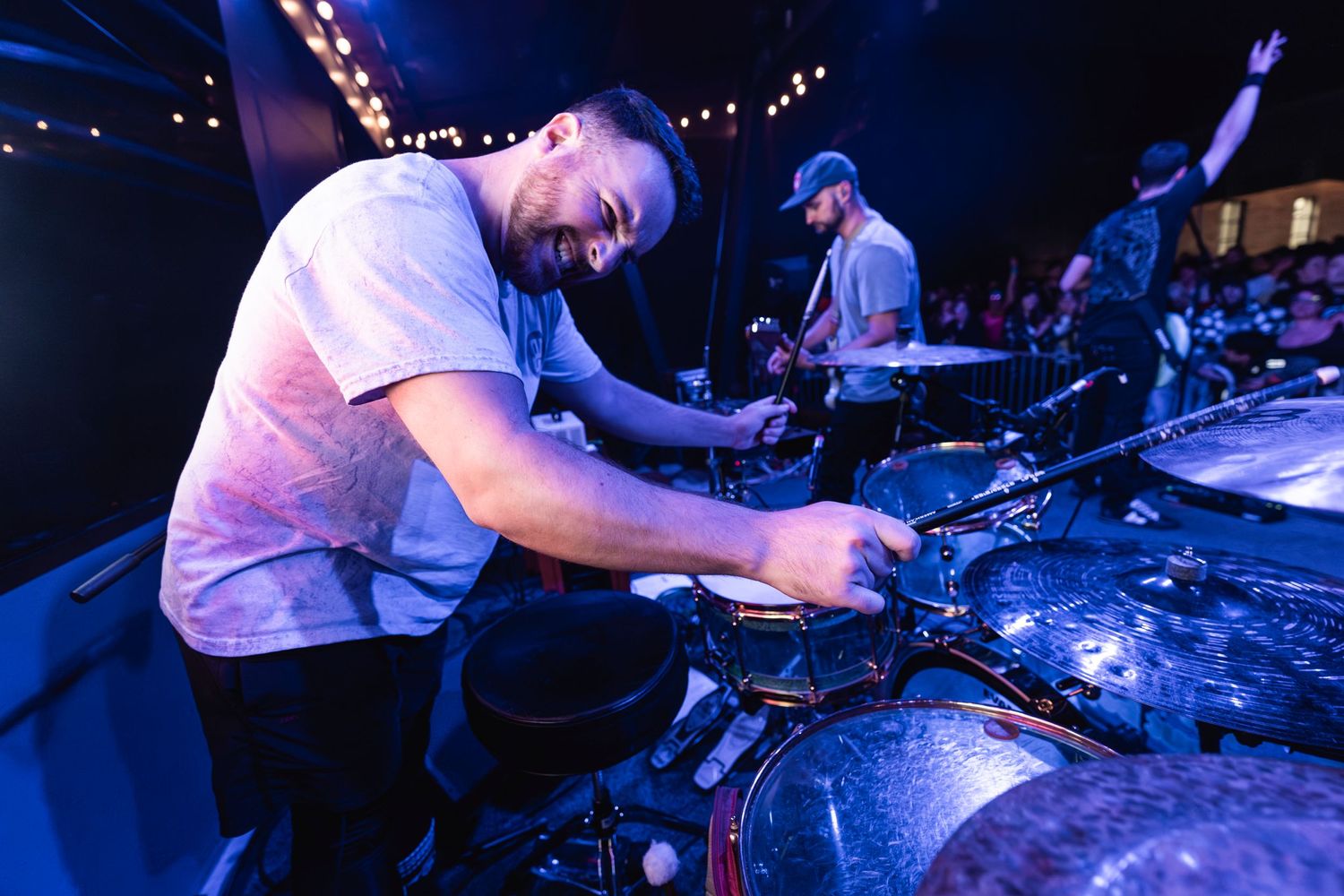 DJ performing at a nightclub with equipment and blue lighting effects.
