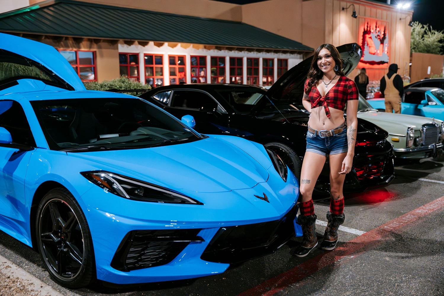 Bright blue Chevrolet Corvette C8 on display at nighttime car show.