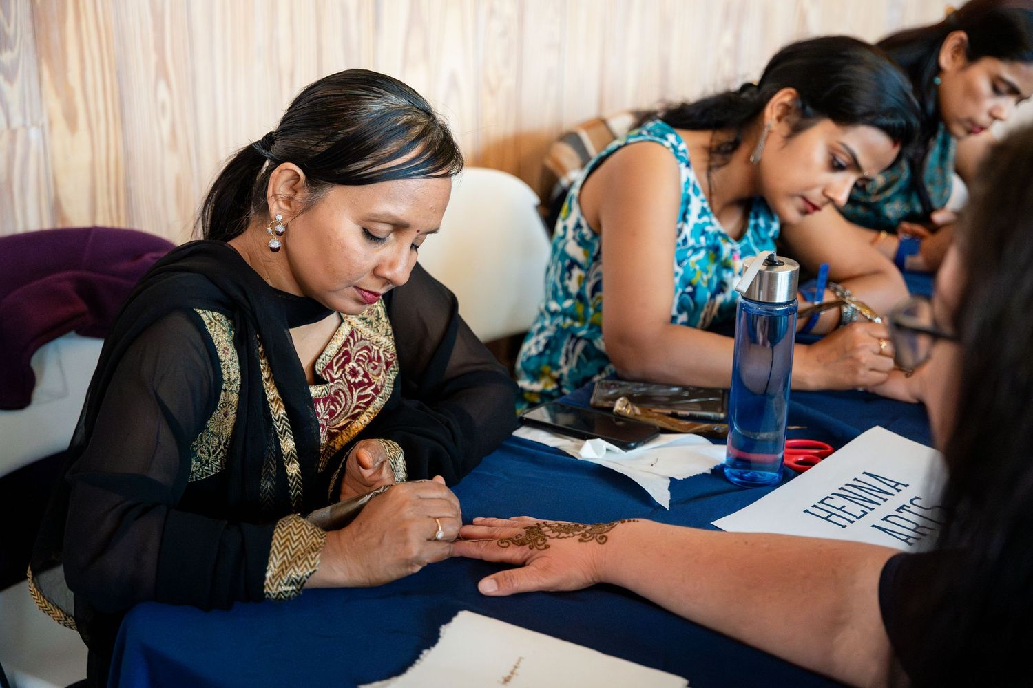 Students work together taking notes and studying during an educational workshop session at a table.