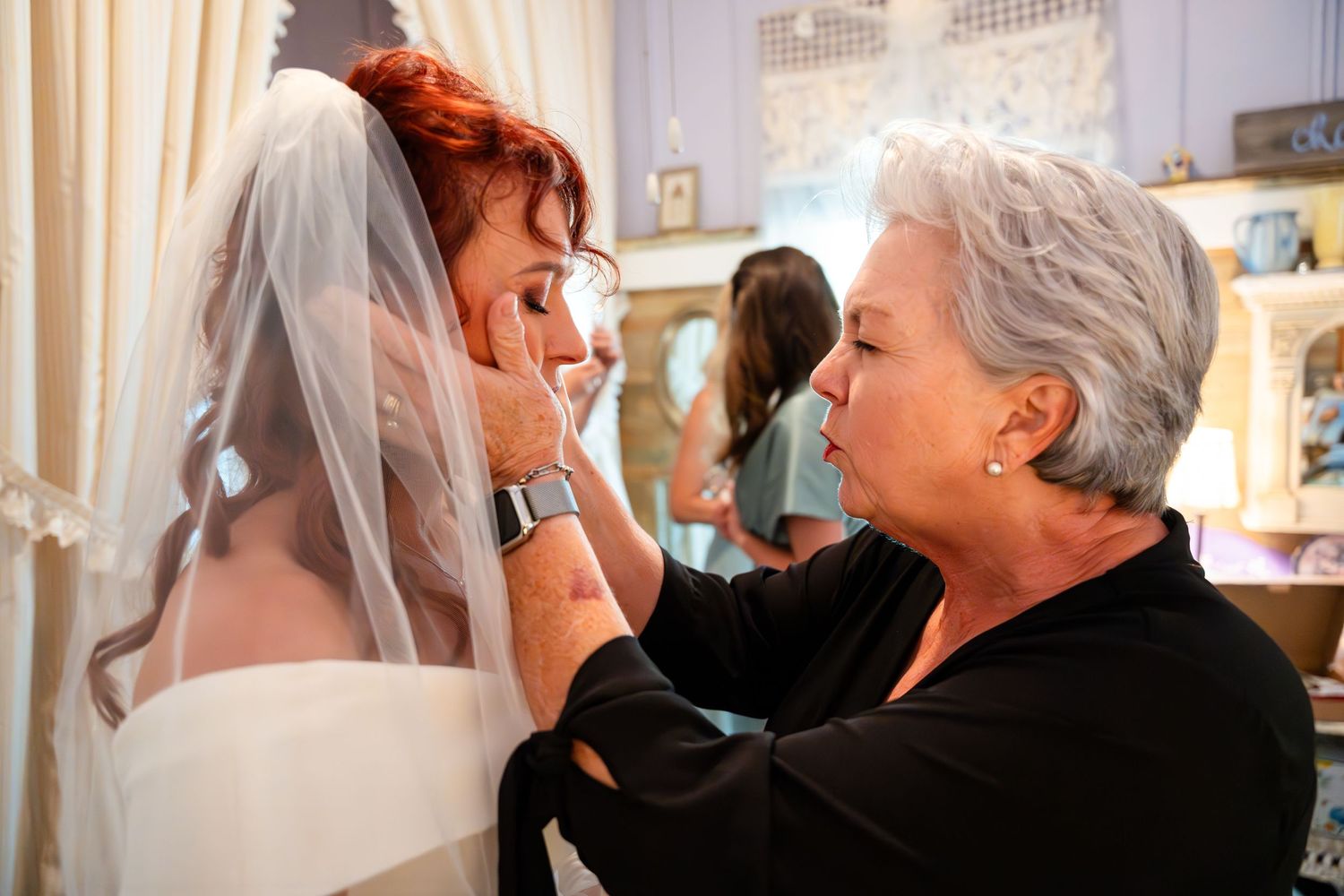 Emotional wedding preparation moment showing caring assistance with bridal accessories.