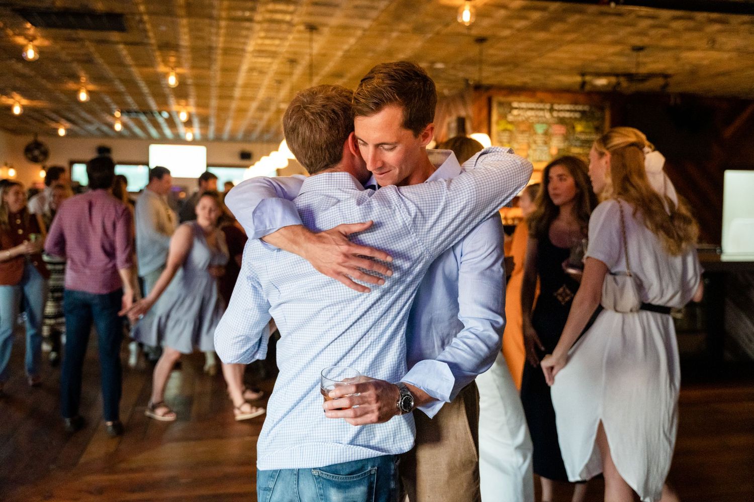 People embracing while dancing at an indoor social event.