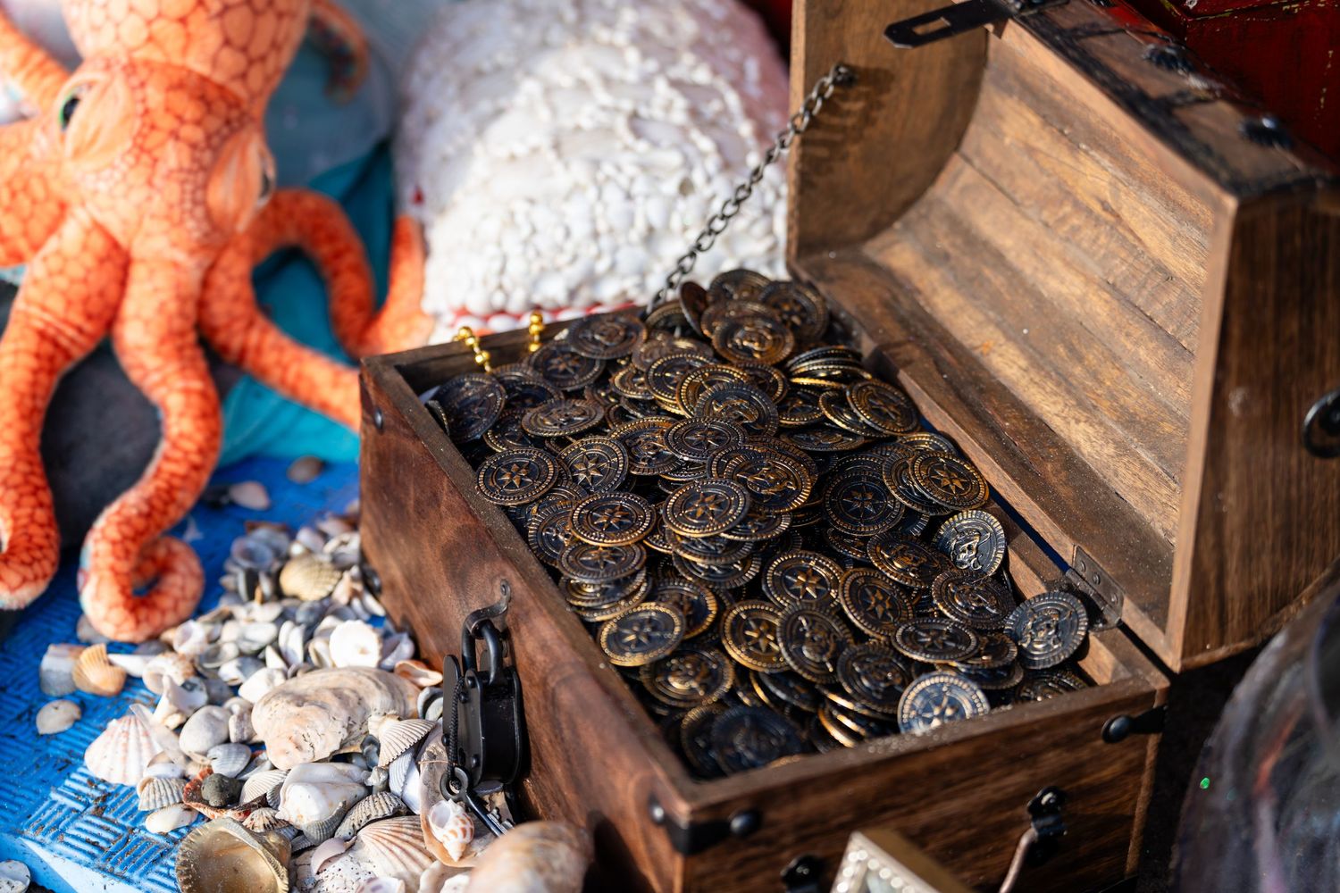 Hands sorting through piles of old coins and currency on a wooden table surface.