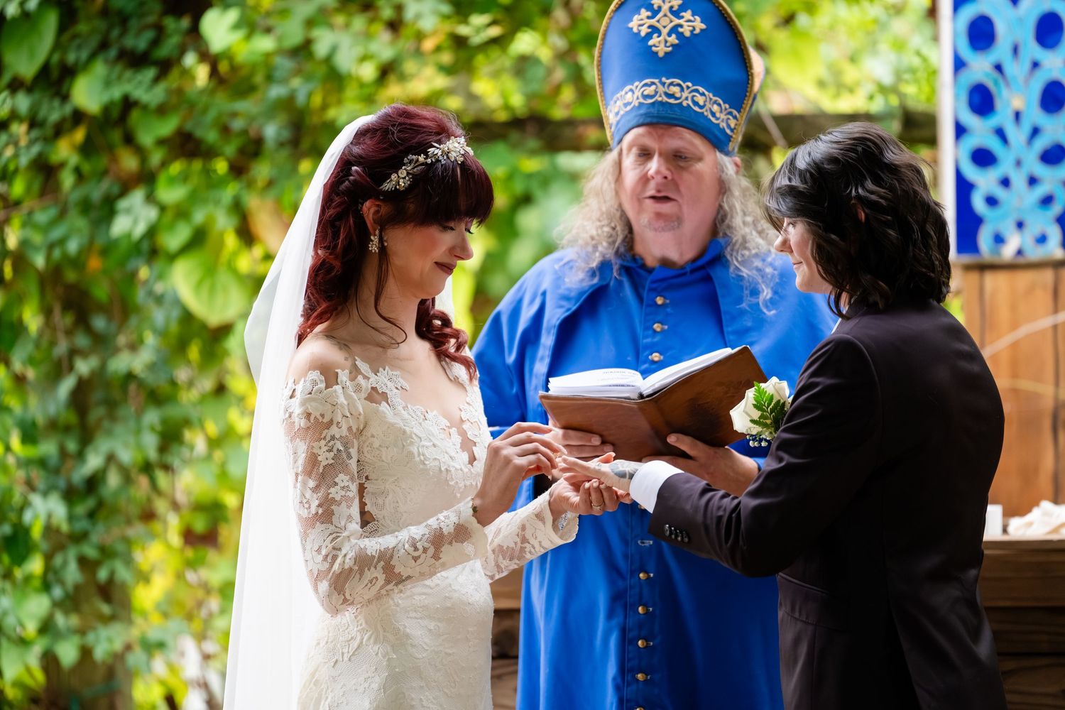A group of people in formal attire gather at an outdoor event with blue and white decorative elements.