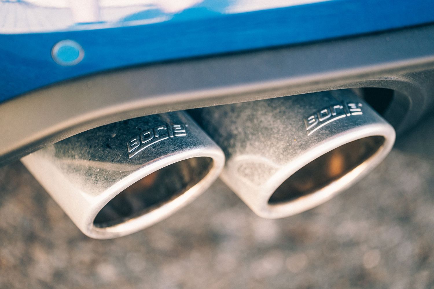 Detail shot of dual chrome exhaust tips on a performance car.