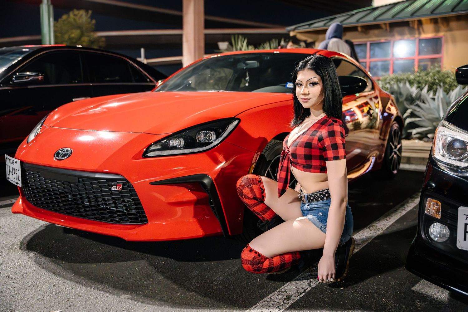 Bright orange Toyota GR86 sports car showcased at outdoor car meet.
