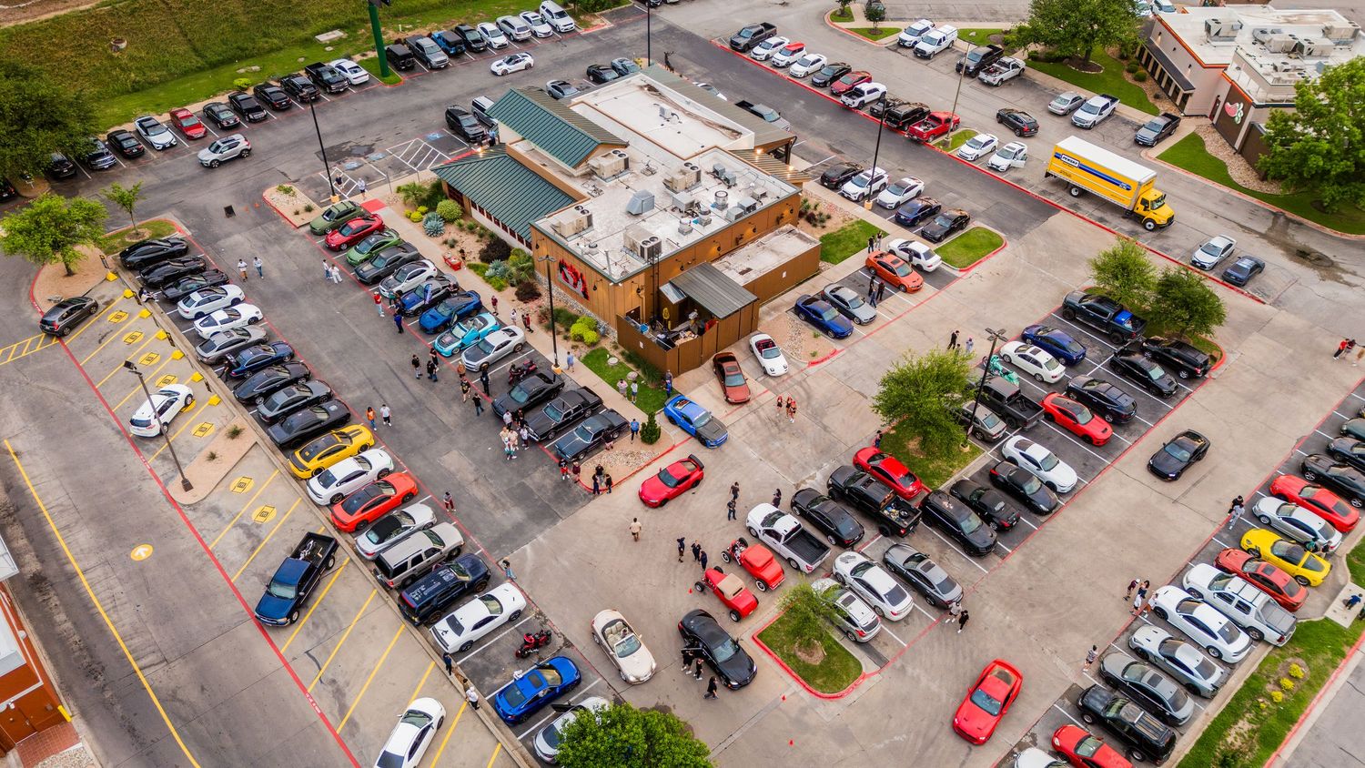 Aerial view of Twin Peaks restaurant with full parking lot and surrounding vehicles.