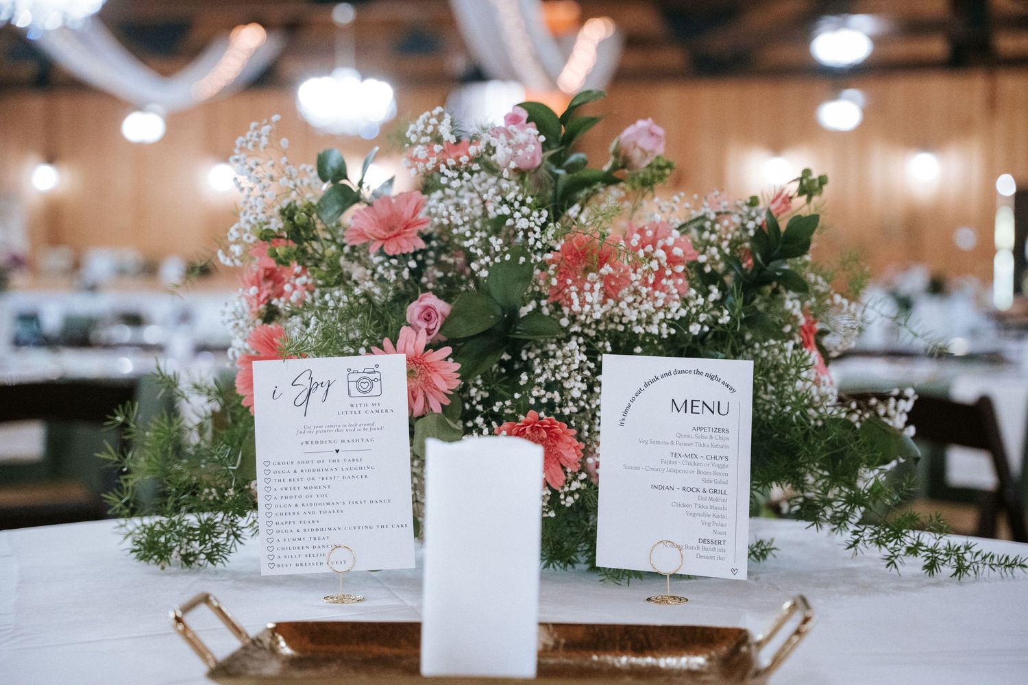 Elegant wedding reception table setting with floral centerpiece and menu cards.