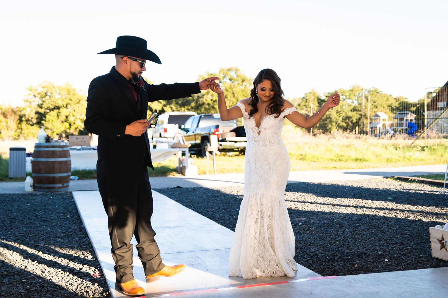 A joyful dancing moment captured at an outdoor wedding reception venue.