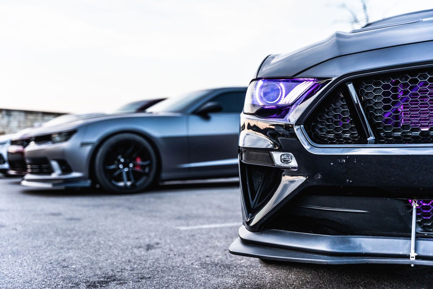 Modern Mustang front end with illuminated purple grille and headlights.