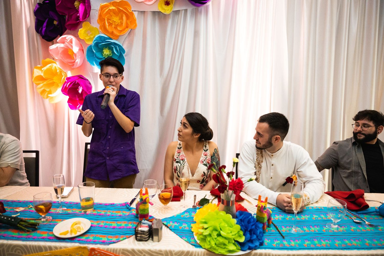 A celebration with colorful balloon decorations and people gathered at a decorated table.