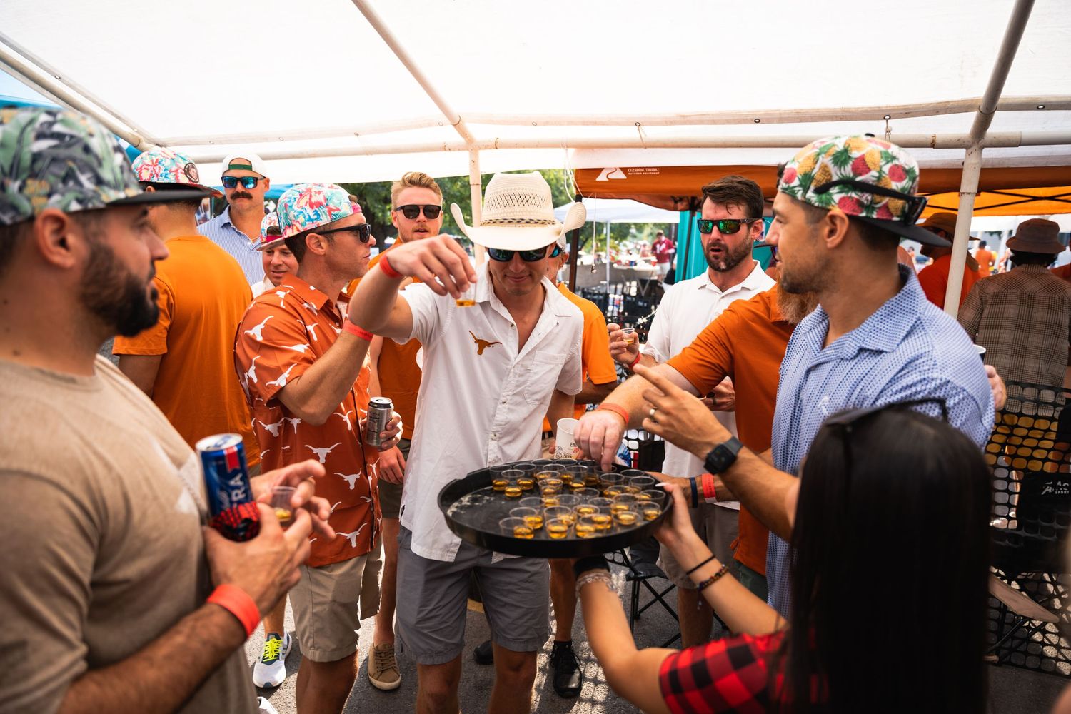 Guests surrounding a tray of appetizers at a festive outdoor gathering.