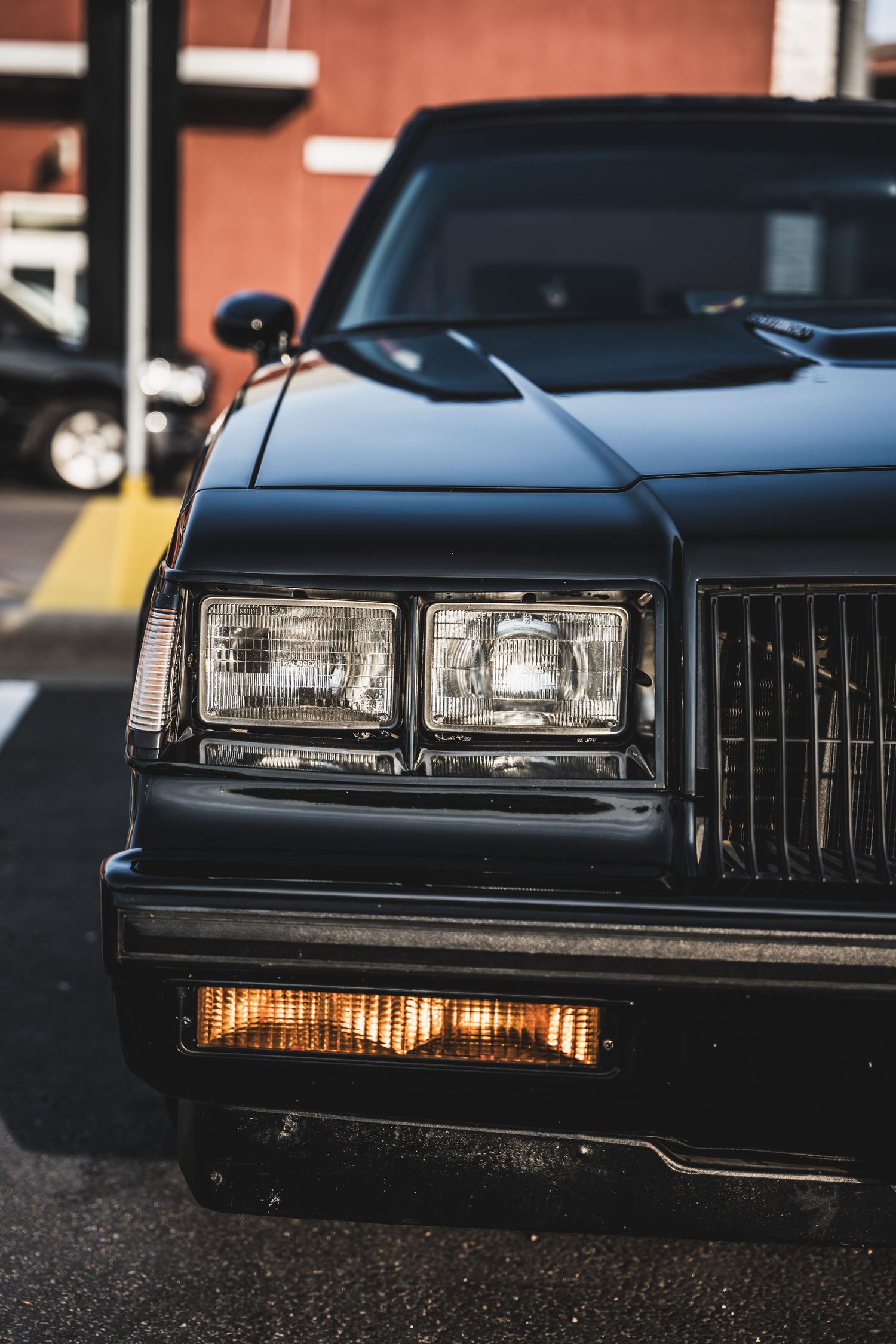 Close-up of black Buick Grand National's iconic front headlights and grille.