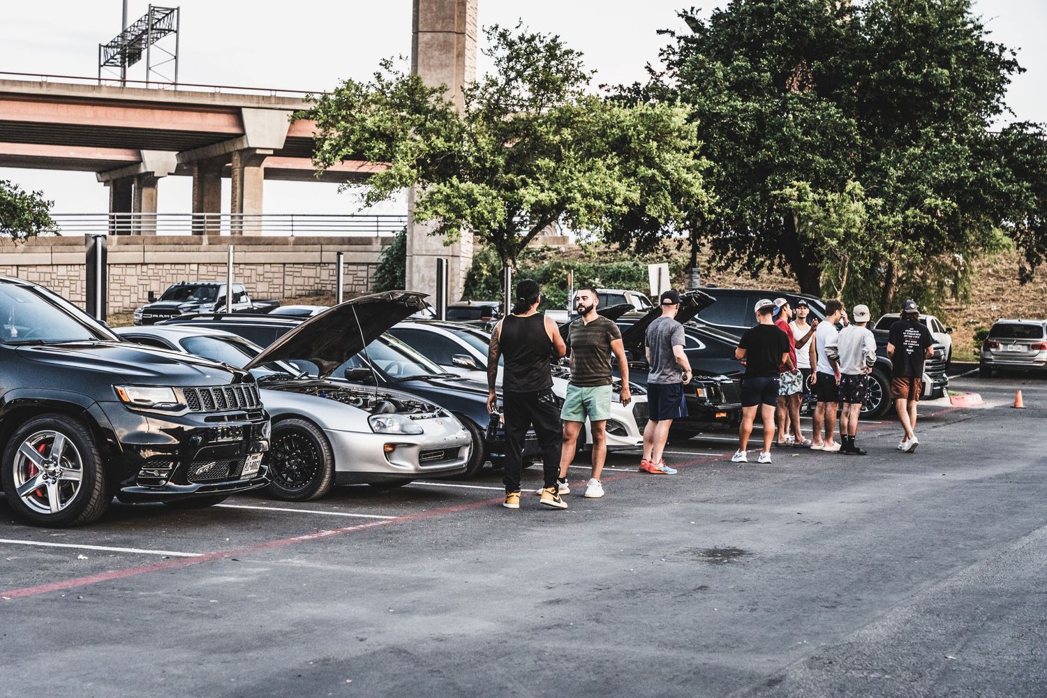 Long line of car enthusiasts gathered around vehicles at an automotive event.