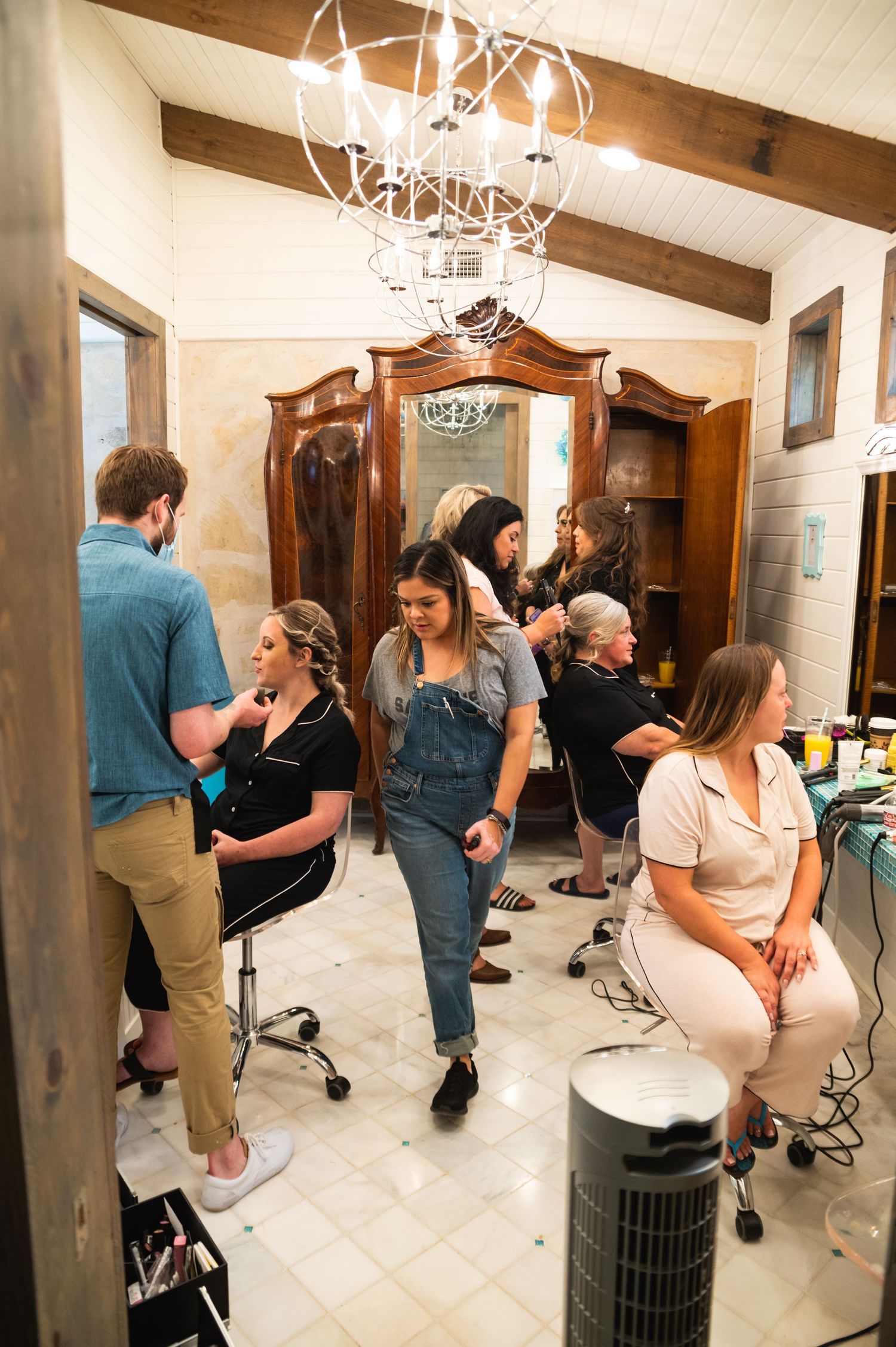 Interior of a salon with antler chandelier and wooden beams on the ceiling.