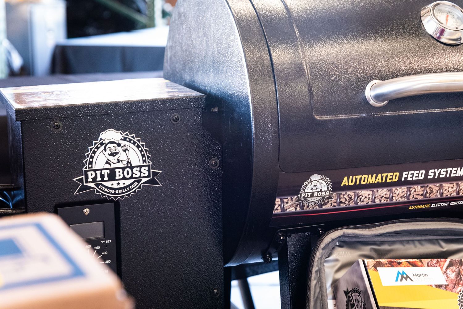 Close-up view of a black Pit Boss smoker grill with logo visible.