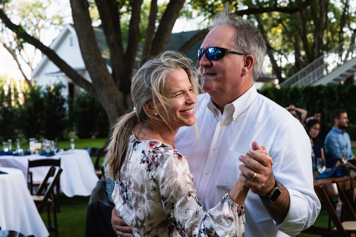 Couple dances joyfully together during an outdoor evening reception.