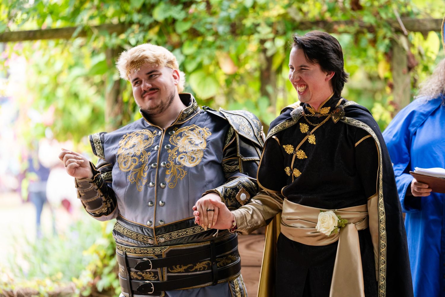 Medieval performers in period costumes entertain guests at a renaissance festival outdoors.
