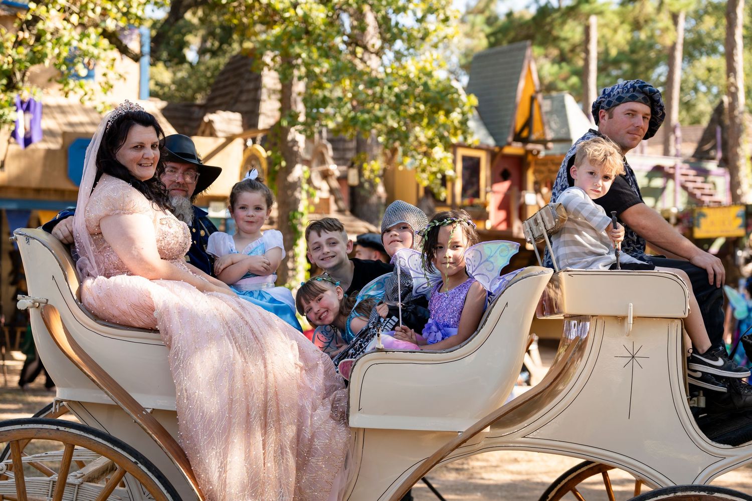 Guests enjoy a spinning teacup ride at an amusement park on a sunny day.
