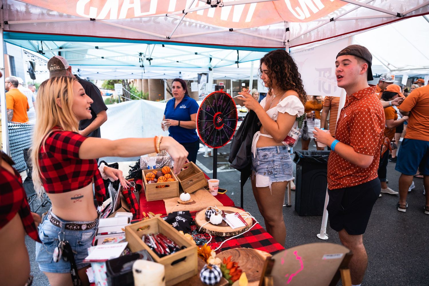 People gathered at outdoor tent party with games and refreshments.
