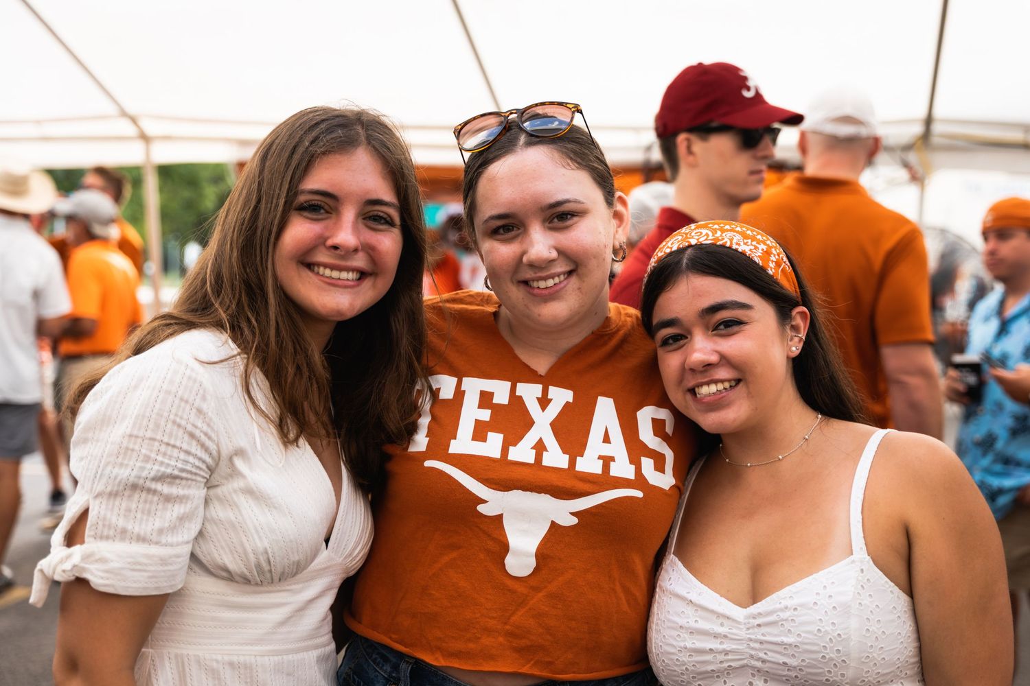 Three friends posing together at a Texas Longhorns themed event.