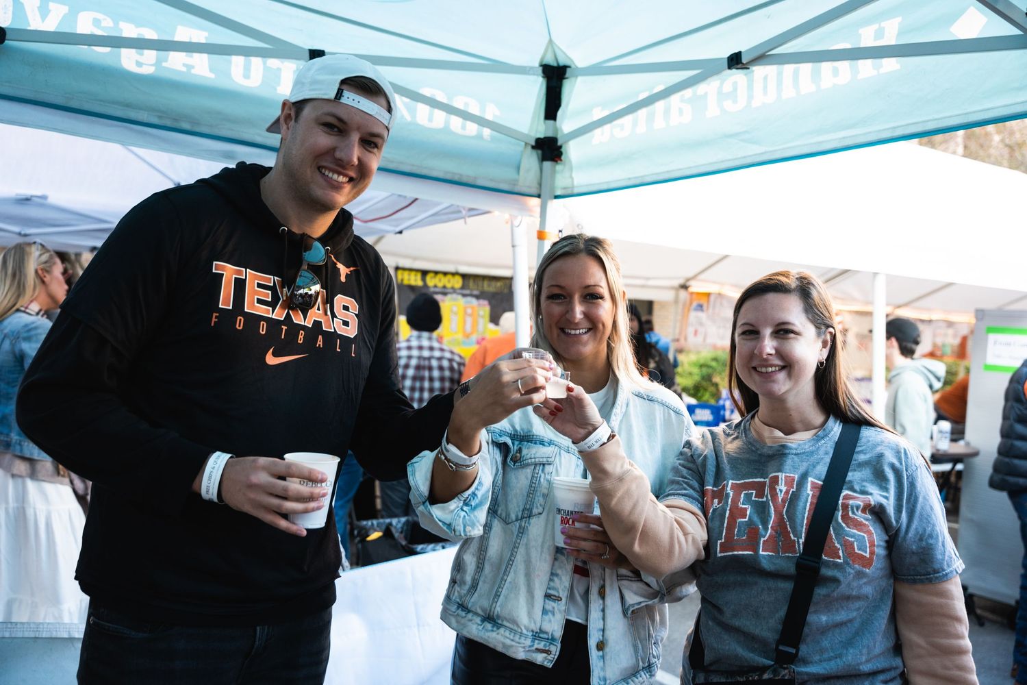 Friends sampling food and drinks together at outdoor Texas event.