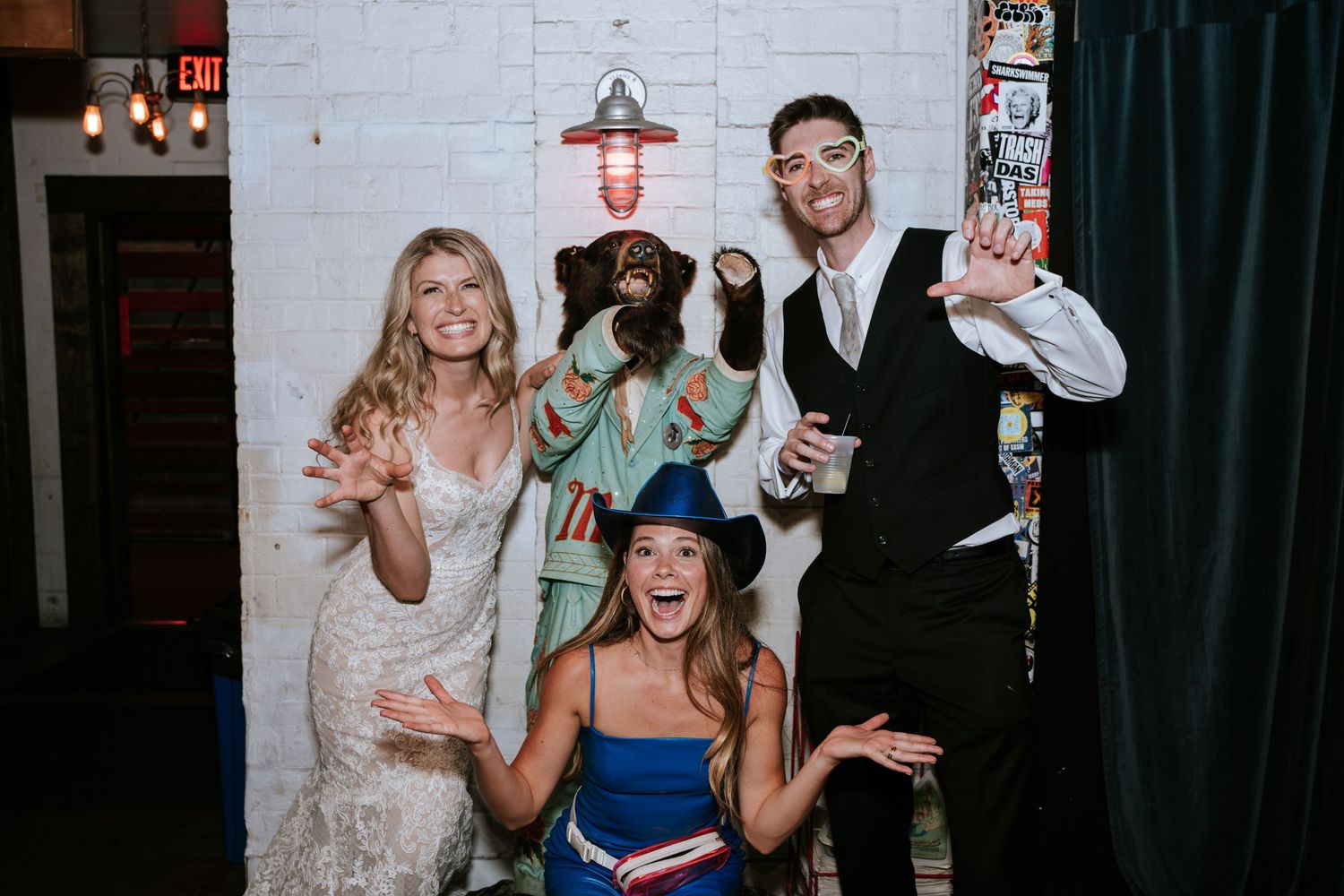 Wedding party poses for fun photo booth style picture with props and costumes.