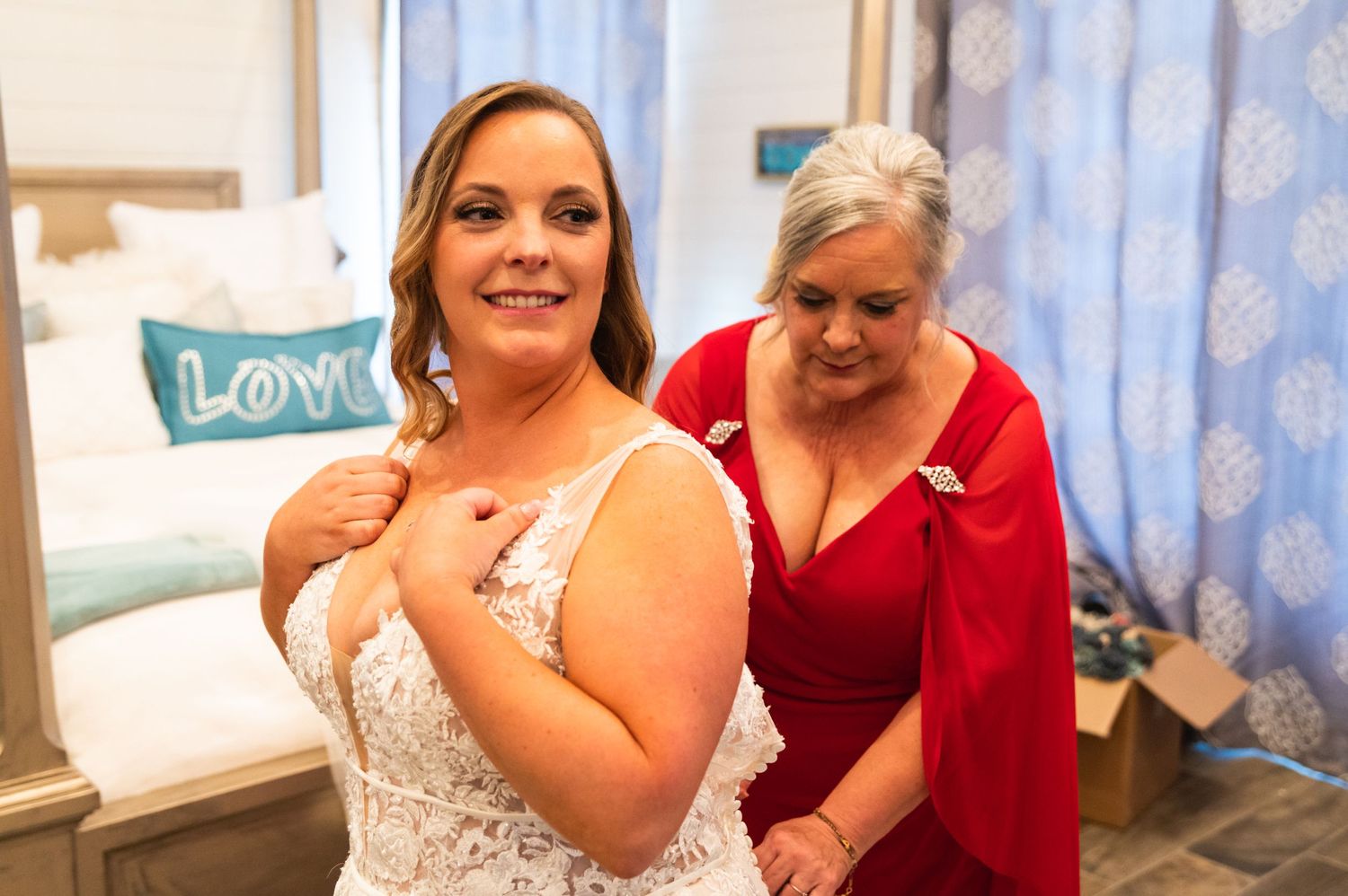Wedding preparations in a blue-curtained room with white and red attire.