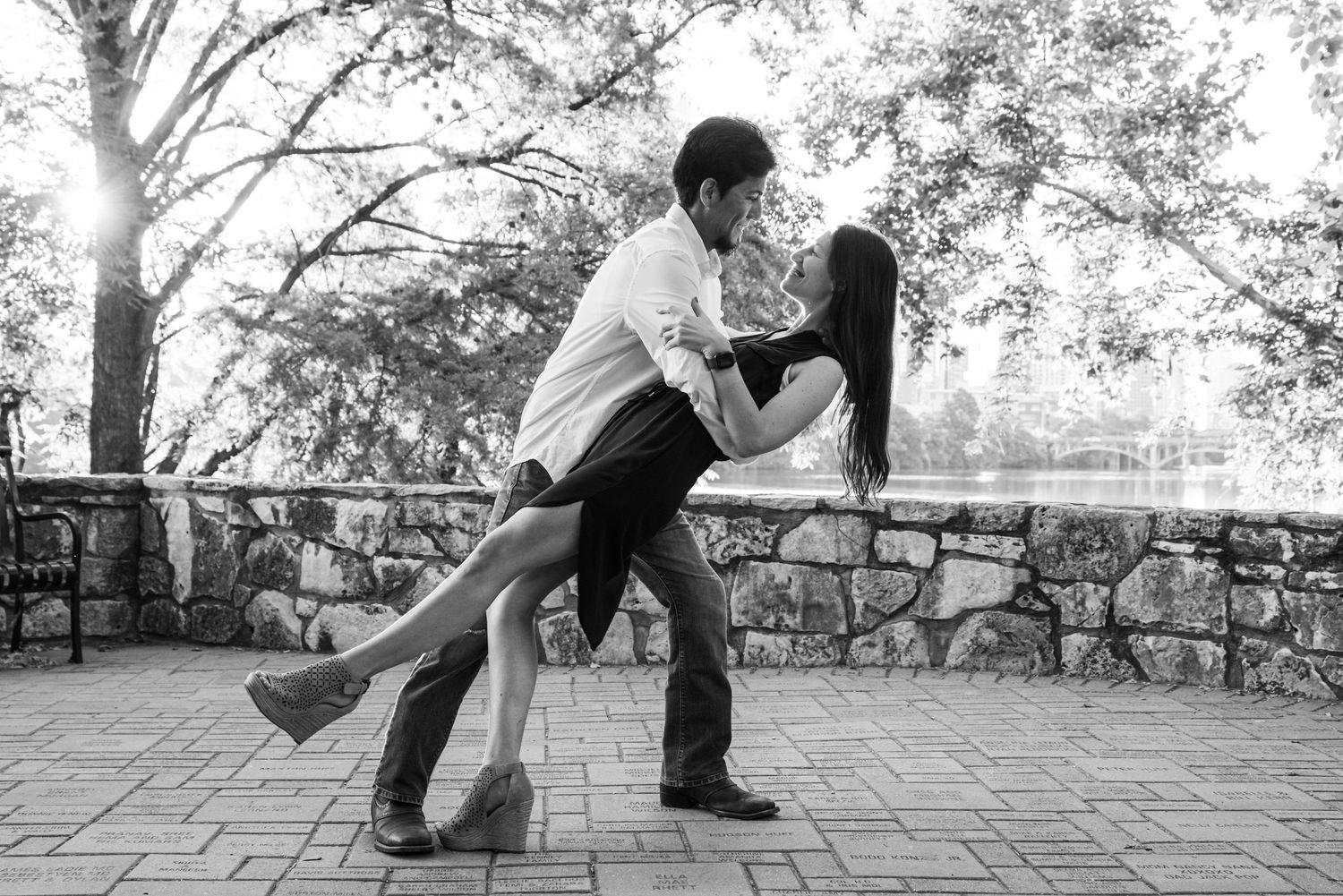 A dramatic black and white dip pose on a stone patio during an engagement session.