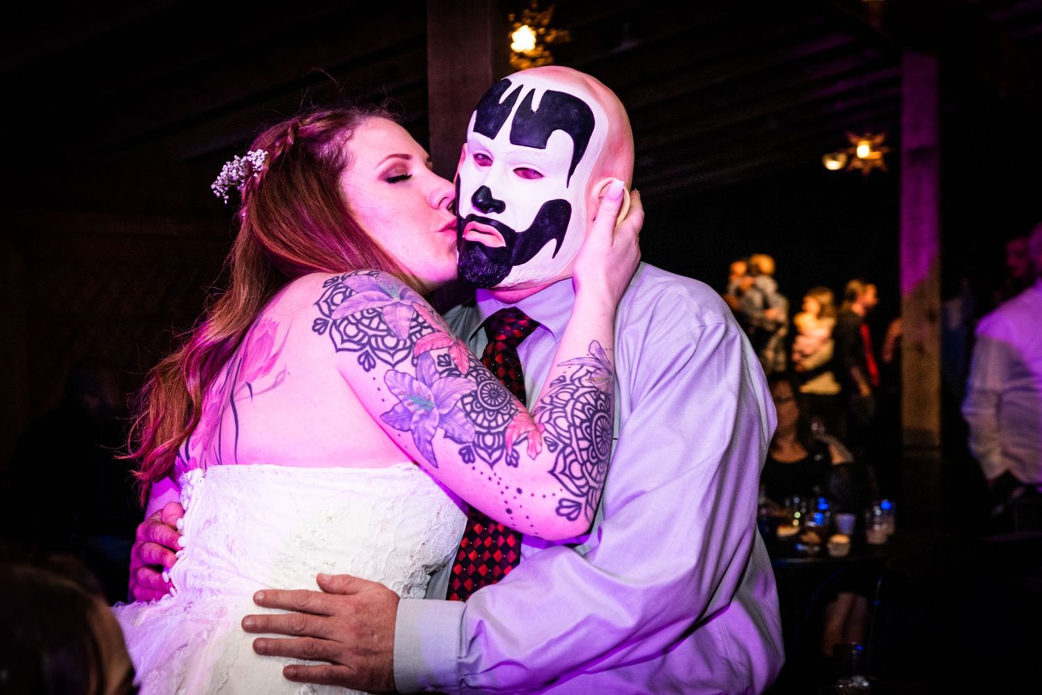 Colorful reception photo showing couple in playful embrace with creative lighting.