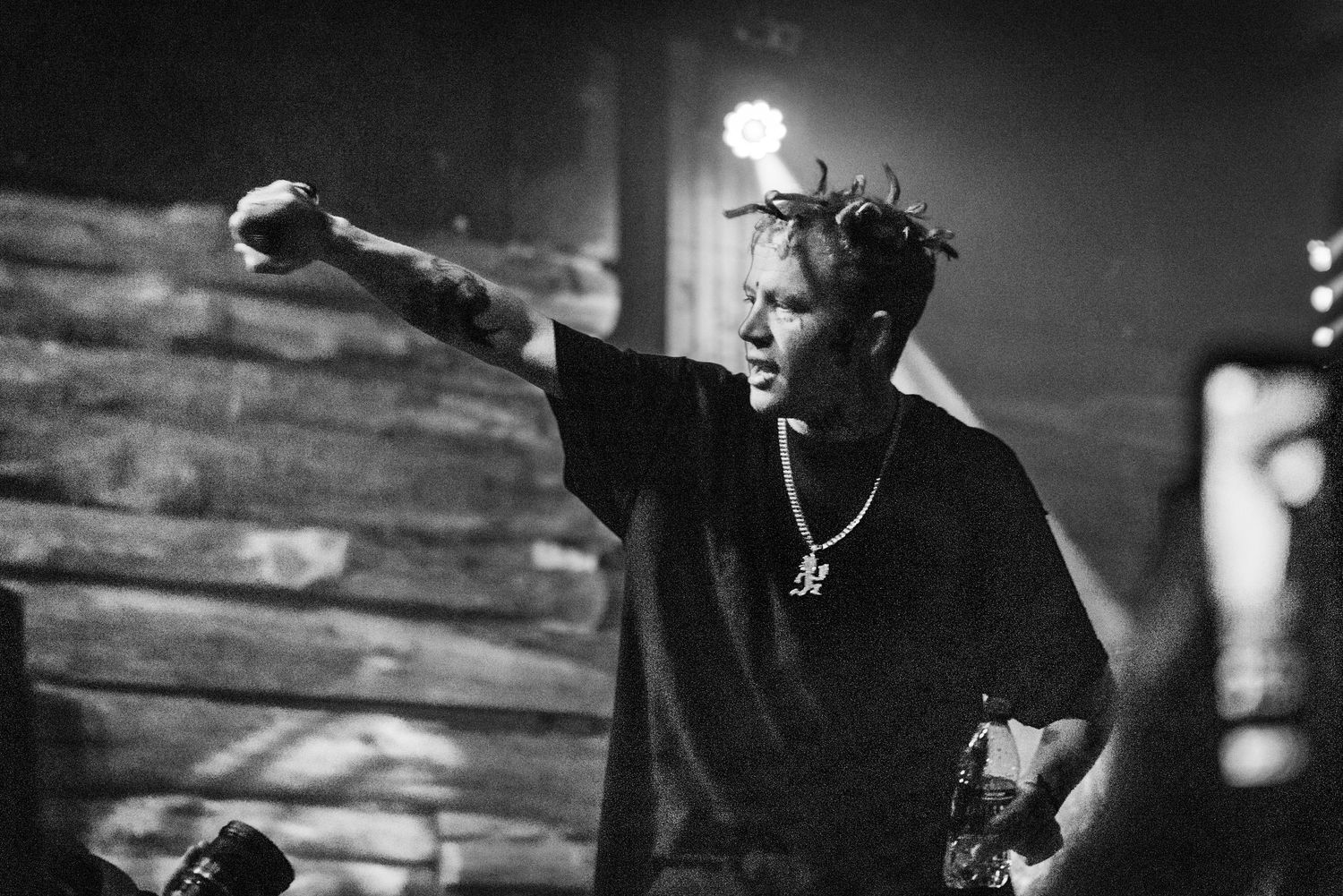 Dramatic black and white photo of performer reaching out during concert performance.