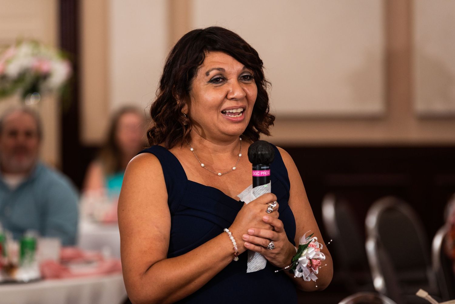 Wedding guest giving a speech with microphone at reception.