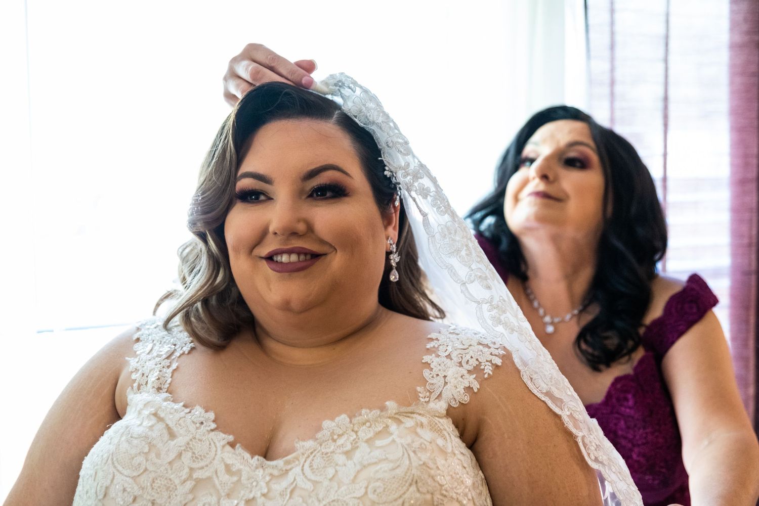 Final bridal preparations with veil being adjusted before the ceremony.