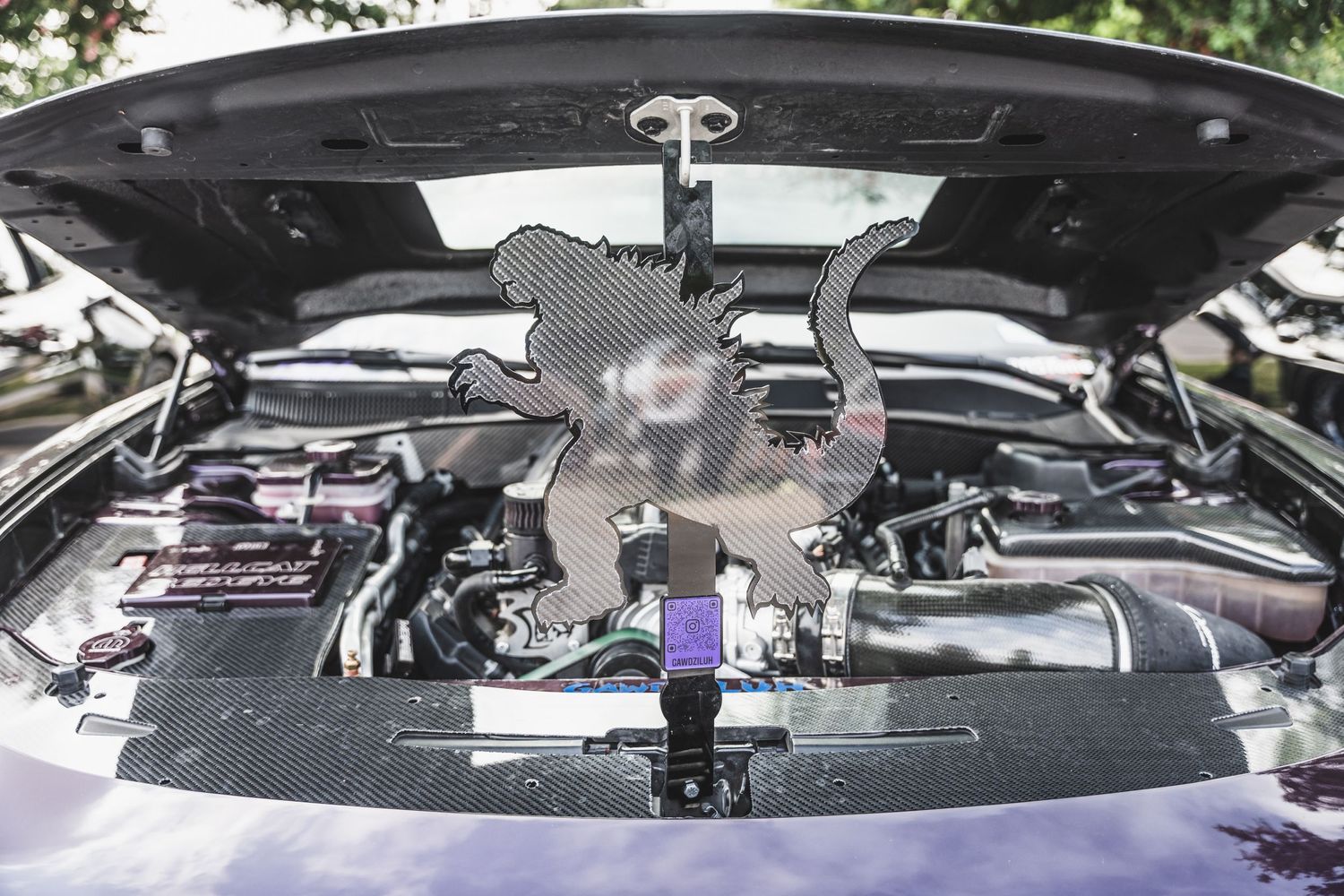 Custom engine bay showing black metal dinosaur decoration mounted above the motor.