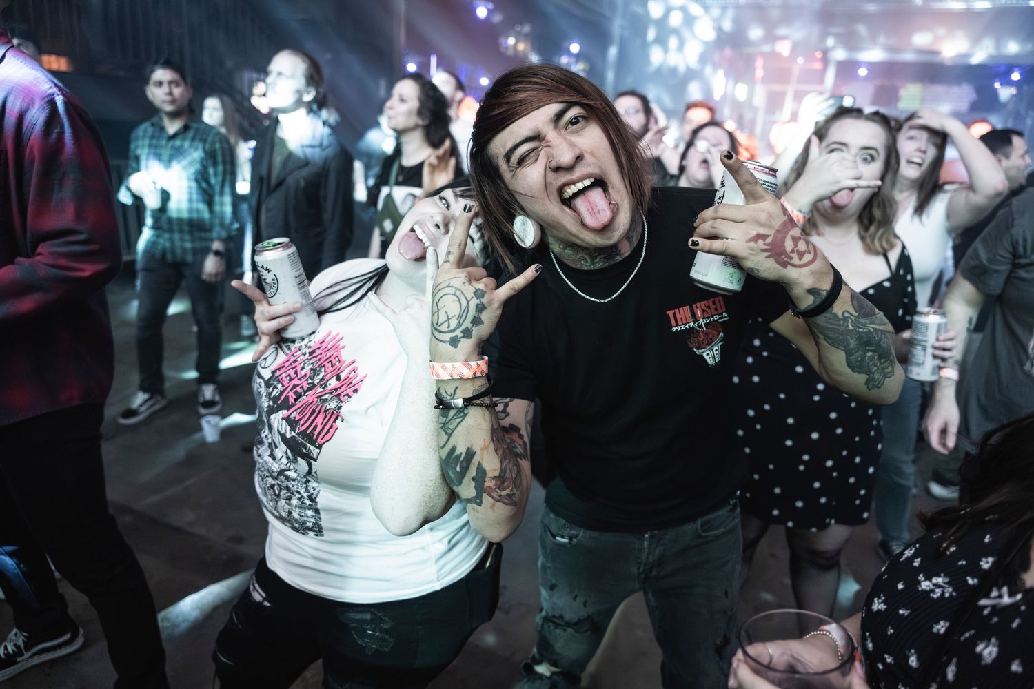 Concert crowd enjoying live music performance with colorful stage lighting.