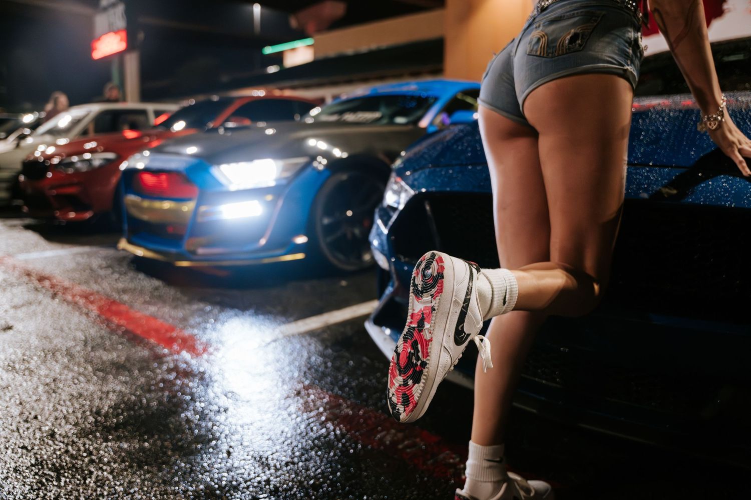 Low angle shot of illuminated sports car at night car show.