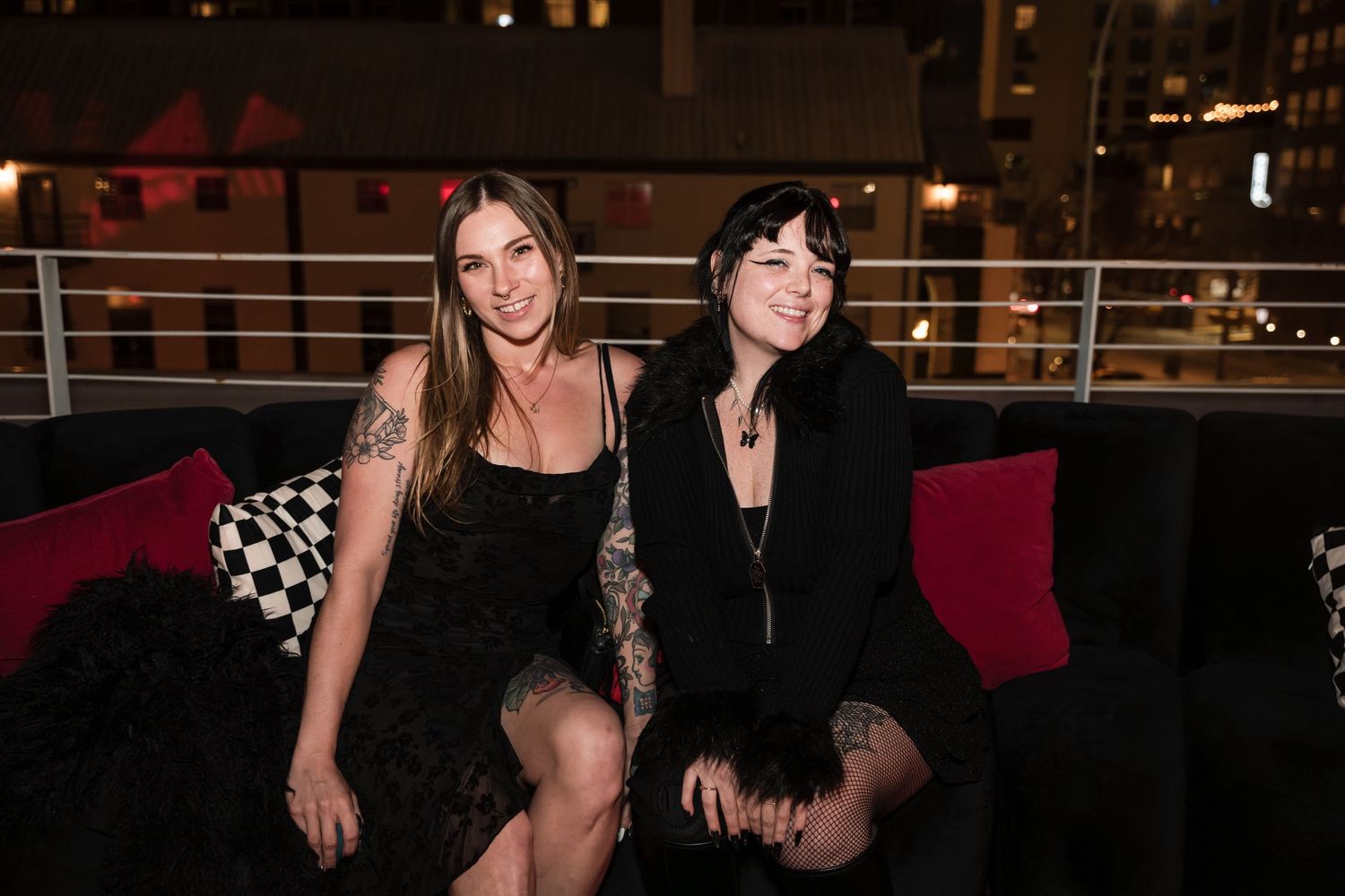 Group of friends posing together at a nightclub or bar in dark lighting with festive atmosphere.