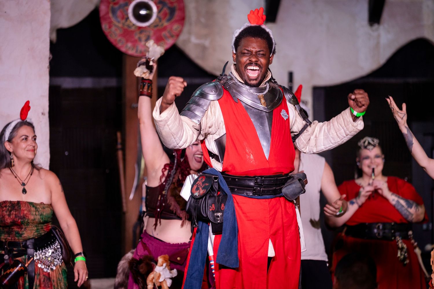 Performers in colorful costumes dance and celebrate during an energetic theatrical show on stage.