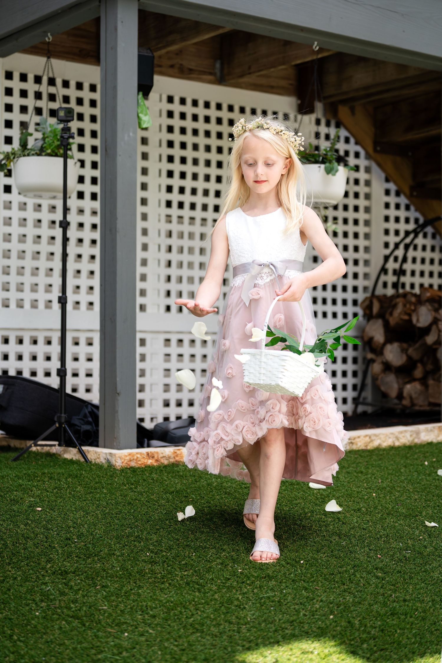 Young attendant in white and pink dress walks gracefully on artificial grass.