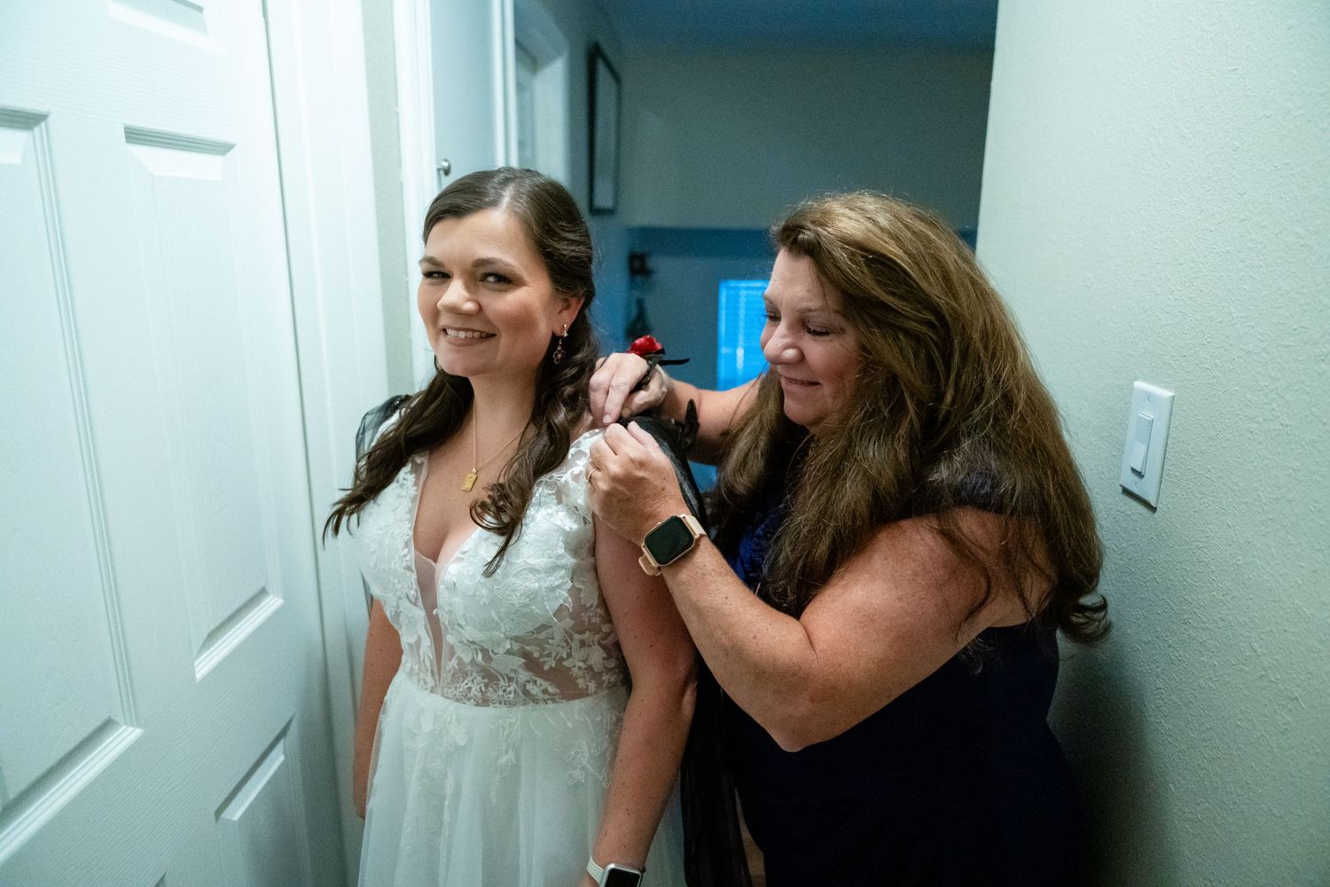 Wedding preparation scene showing final touches being made to bridal attire.