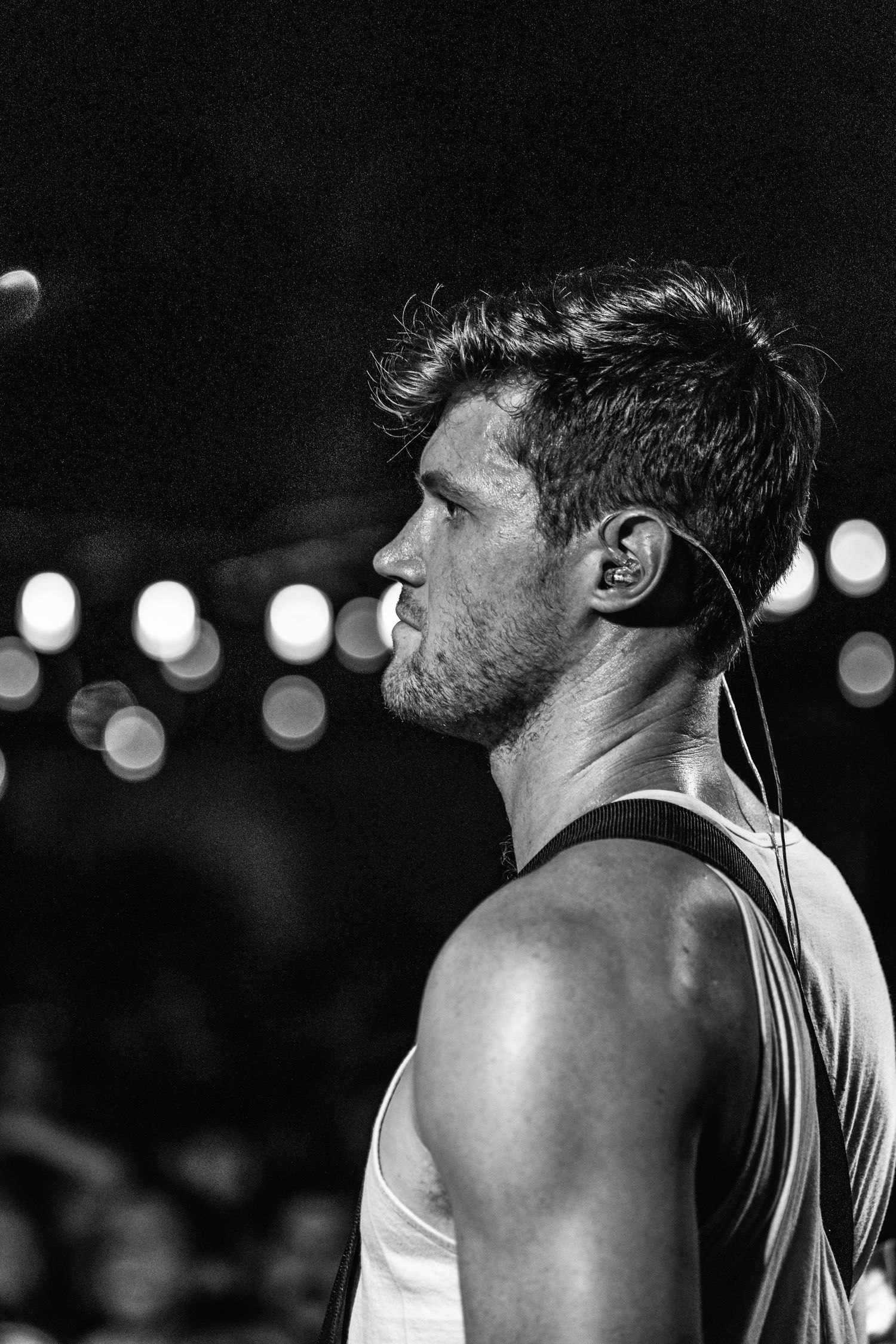 Black and white profile shot of a performer under stage lights.