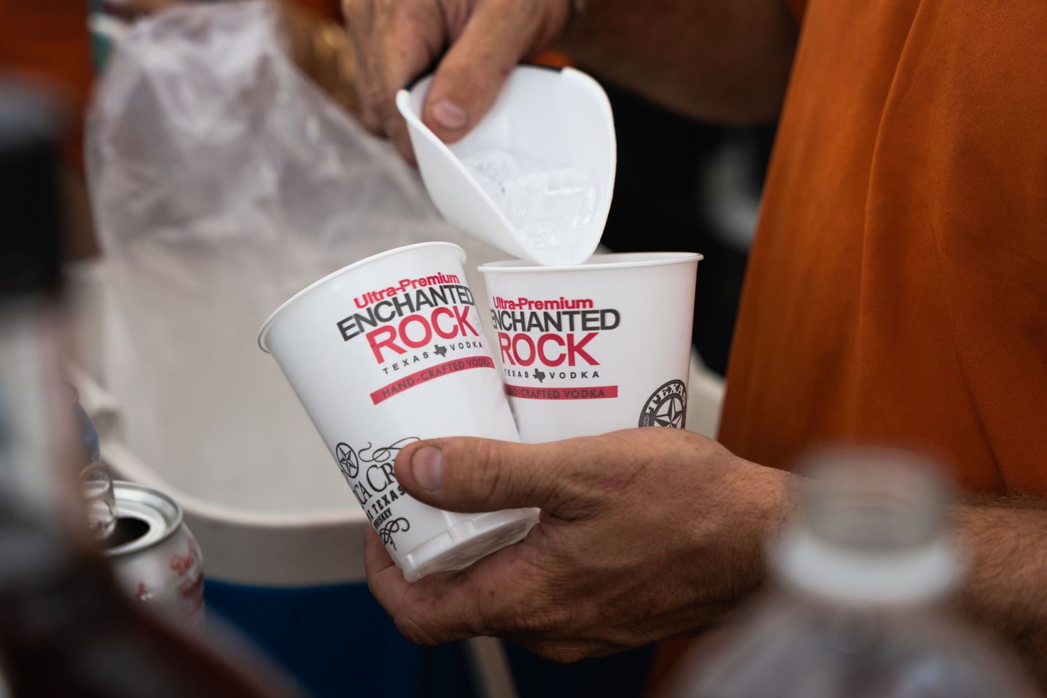 Hands hold a white food container with red text labeling.