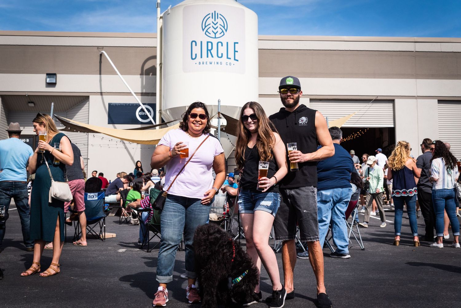 Customers enjoying drinks outside Circle Brewing Company on a sunny afternoon.