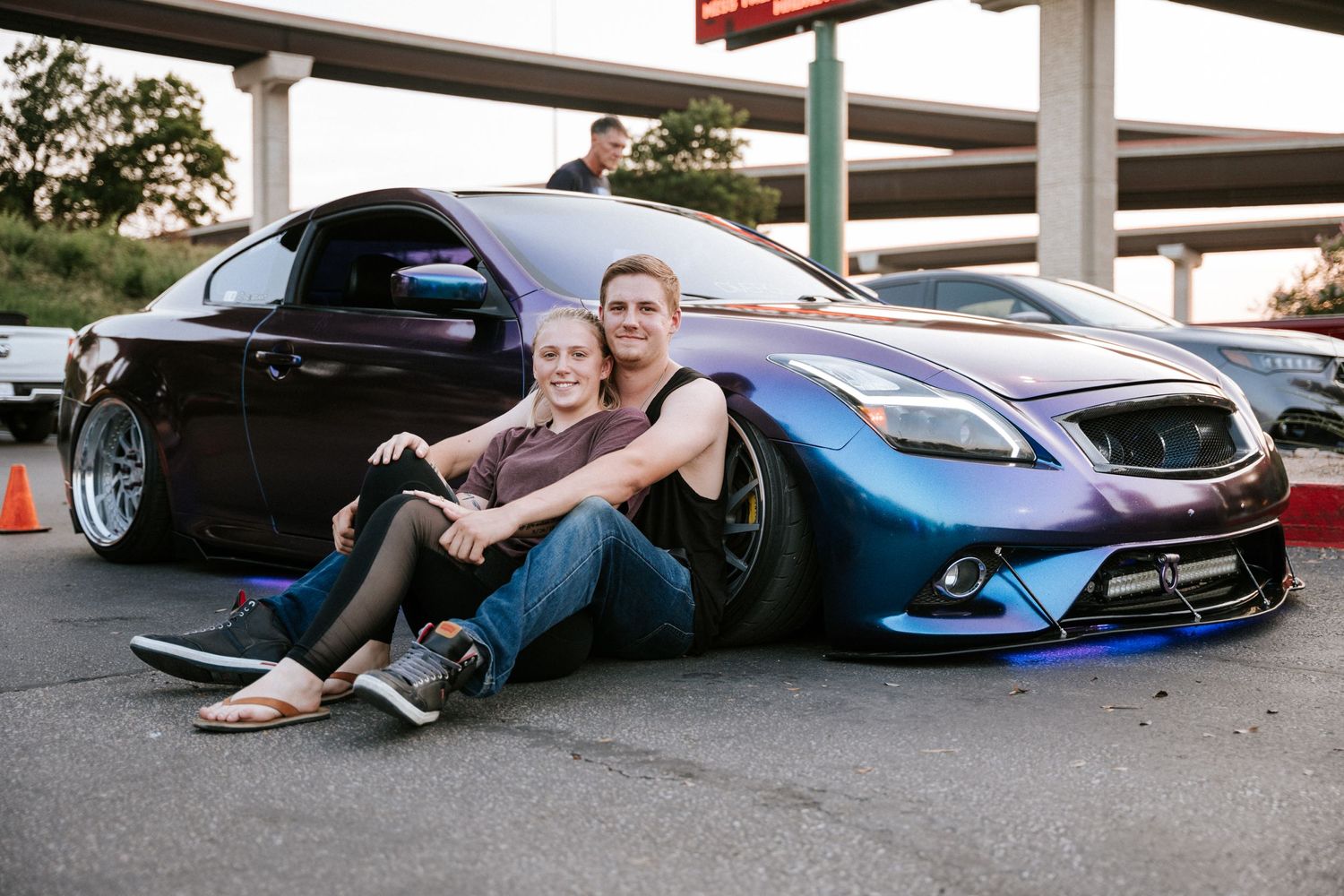 Custom blue Infiniti G37 lowered on aftermarket wheels at car meet.